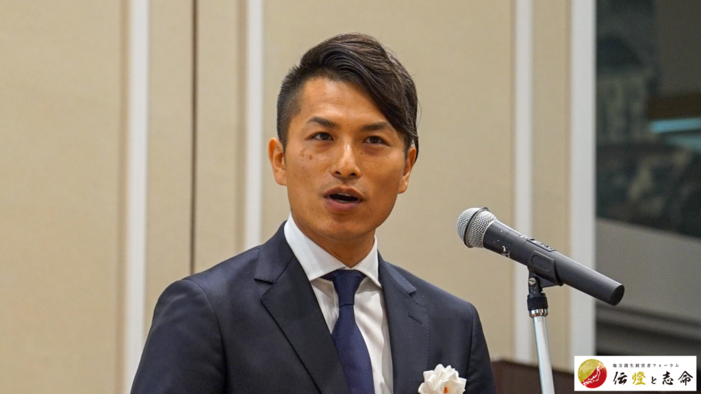 第 16 回 地方創生経営者フォーラム 伝燈と志命 in 新潟 2025で主催挨拶をしている智慧の燈火プロジェクト発起人 田中 雅也